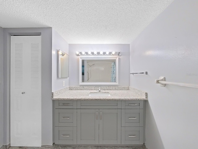 bathroom featuring a textured ceiling and vanity