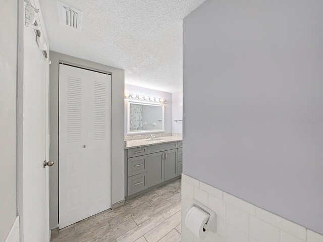 bathroom with vanity, a textured ceiling, and hardwood / wood-style floors