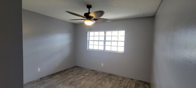 spare room with hardwood / wood-style floors, ceiling fan, and a textured ceiling