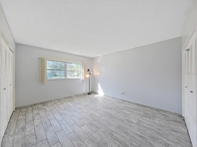 unfurnished bedroom with light hardwood / wood-style floors and a textured ceiling