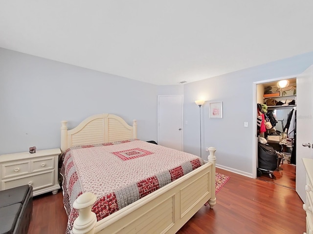 bedroom featuring a closet, a spacious closet, and dark hardwood / wood-style floors