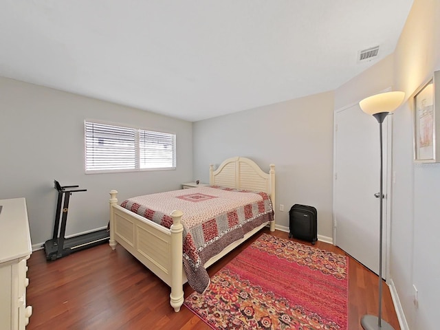 bedroom with dark wood-type flooring