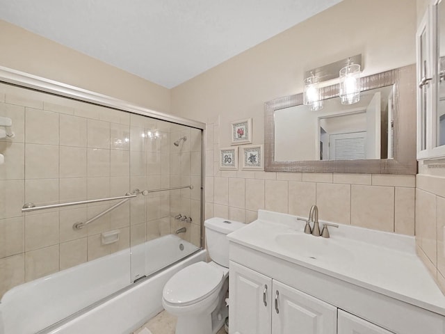 full bathroom with toilet, tile walls, bath / shower combo with glass door, decorative backsplash, and vanity