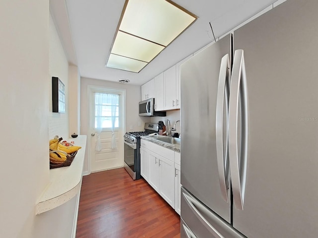 kitchen featuring sink, appliances with stainless steel finishes, dark hardwood / wood-style flooring, and white cabinets