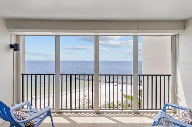 unfurnished sunroom with a beach view and a water view