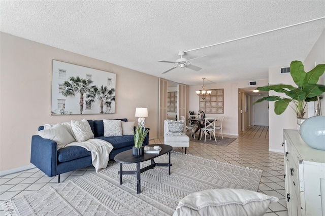 living room with a textured ceiling, light tile patterned floors, and ceiling fan with notable chandelier