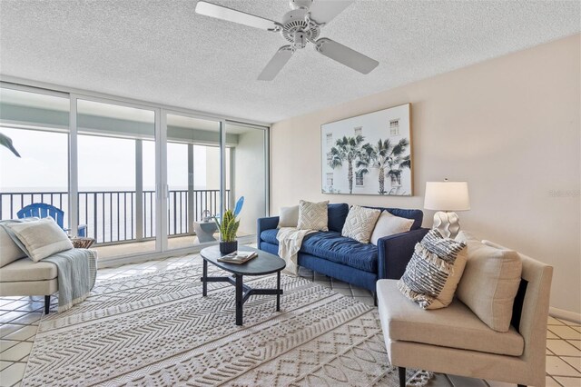 tiled living room with a textured ceiling, expansive windows, and ceiling fan