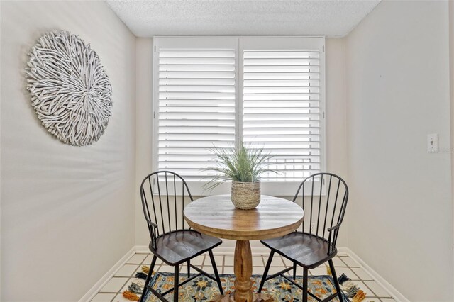 tiled dining space featuring a textured ceiling