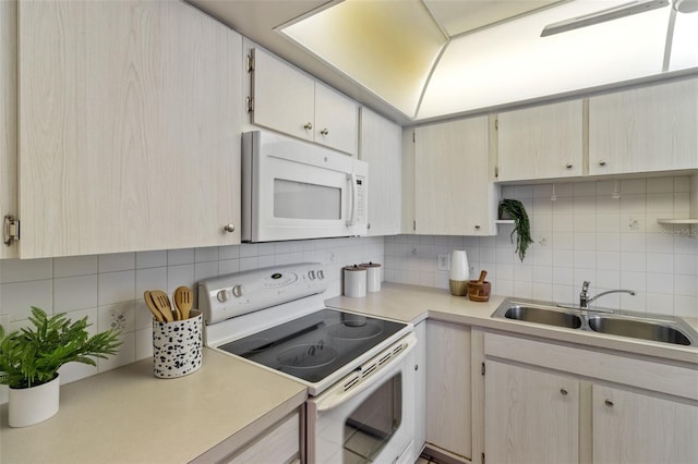 kitchen featuring white appliances, light brown cabinetry, sink, and tasteful backsplash