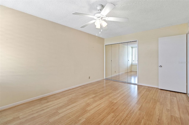 unfurnished bedroom with a textured ceiling, ceiling fan, a closet, and light hardwood / wood-style floors