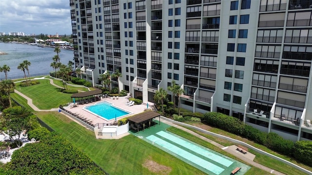 view of swimming pool with a yard and a water view