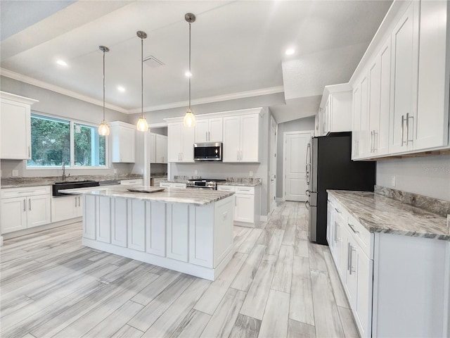 kitchen featuring white cabinets, hanging light fixtures, stainless steel appliances, a center island, and light stone countertops