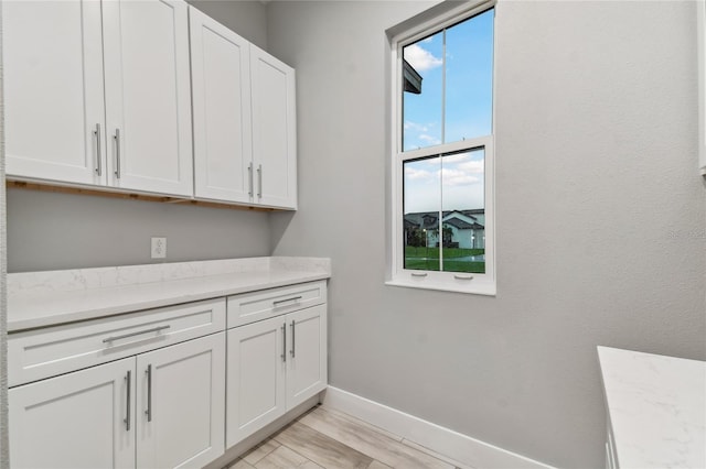 laundry area with light wood-type flooring