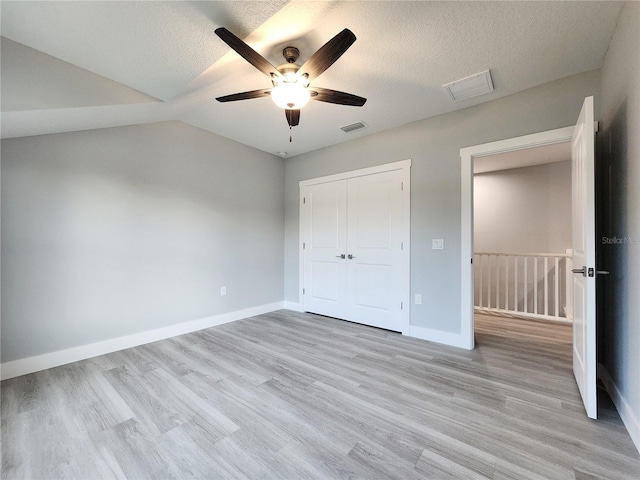 unfurnished bedroom featuring a textured ceiling, light wood-type flooring, and ceiling fan