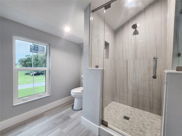 bathroom featuring walk in shower, a textured ceiling, hardwood / wood-style floors, and toilet