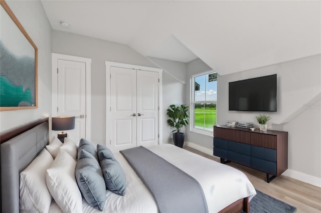 bedroom featuring light hardwood / wood-style flooring and lofted ceiling