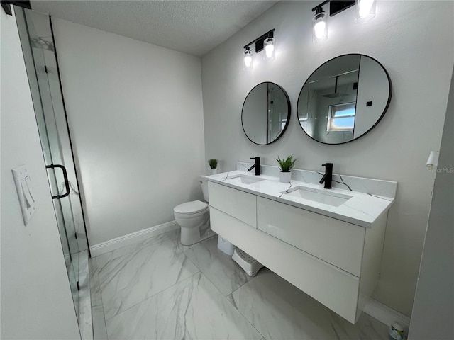 bathroom with a textured ceiling, toilet, vanity, and a shower with door