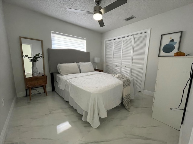 bedroom featuring a textured ceiling, ceiling fan, and a closet