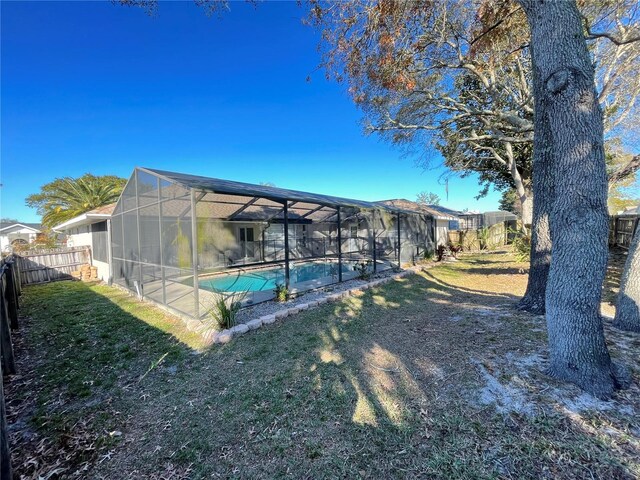 view of yard featuring a fenced in pool and glass enclosure