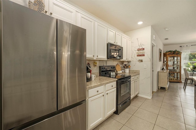 kitchen featuring tasteful backsplash, light tile patterned floors, black appliances, light stone countertops, and white cabinets