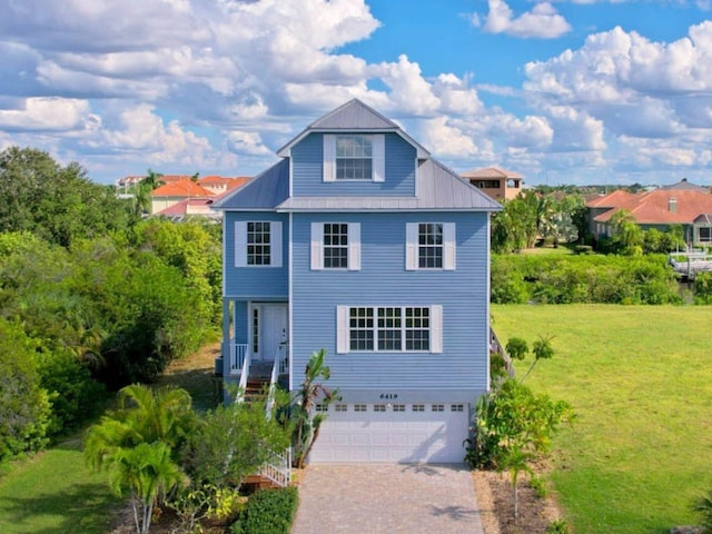 6419 Marbella Blvd, Apollo Beach, FL 33572 - view of front of property featuring decorative driveway, an attached garage, a front lawn, and metal roof