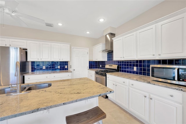 6419 Marbella Blvd, Apollo Beach, FL 33572 - kitchen with stainless steel appliances, wall chimney exhaust hood, white cabinetry, decorative backsplash, and recessed lighting