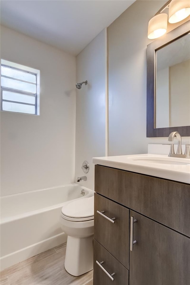 full bathroom with toilet, hardwood / wood-style flooring, shower / washtub combination, and vanity