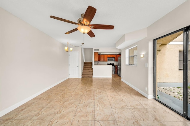 unfurnished living room featuring visible vents, ceiling fan with notable chandelier, and baseboards