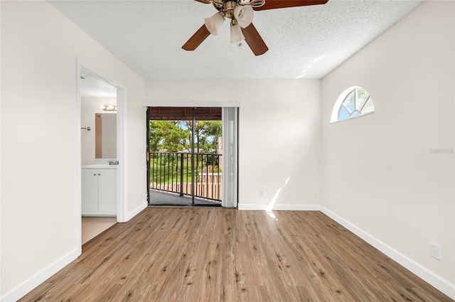 spare room with a textured ceiling, light hardwood / wood-style flooring, and ceiling fan