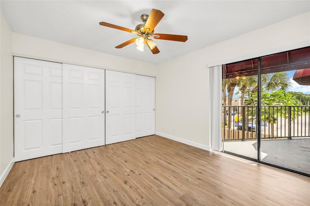 unfurnished bedroom featuring a ceiling fan, wood finished floors, baseboards, access to exterior, and a closet