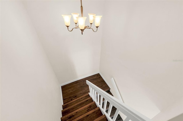 stairs with baseboards, an inviting chandelier, and wood finished floors