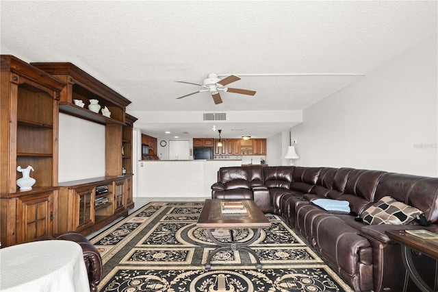 living room with a textured ceiling and ceiling fan