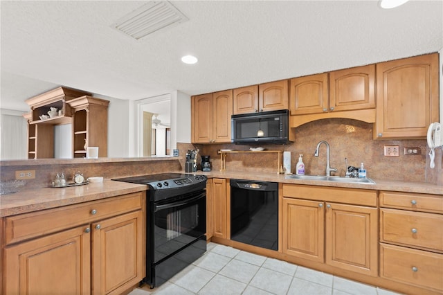 kitchen featuring a textured ceiling, black appliances, sink, decorative backsplash, and light tile patterned flooring