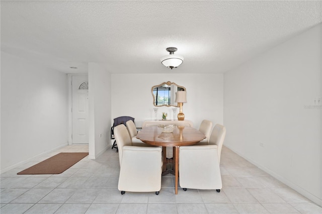 tiled dining area with a textured ceiling