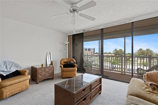 carpeted living room with a textured ceiling and ceiling fan