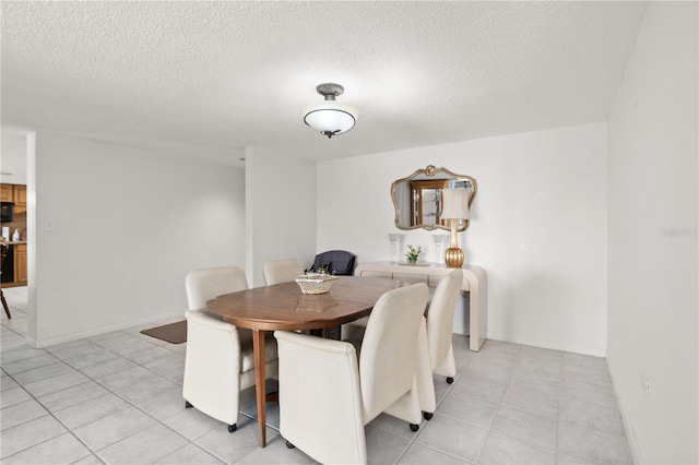 dining room featuring a textured ceiling and light tile patterned flooring