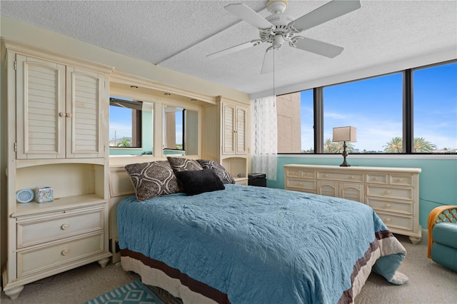 bedroom with a textured ceiling, ceiling fan, and carpet floors