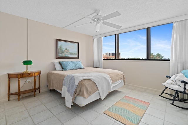 tiled bedroom with a textured ceiling and ceiling fan