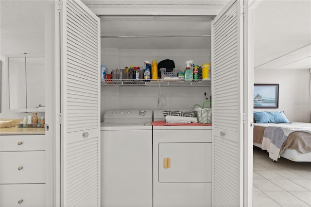 clothes washing area with light tile patterned floors and independent washer and dryer