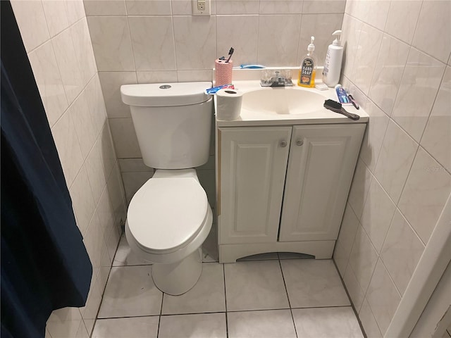 bathroom with vanity, toilet, tile walls, and tile patterned flooring