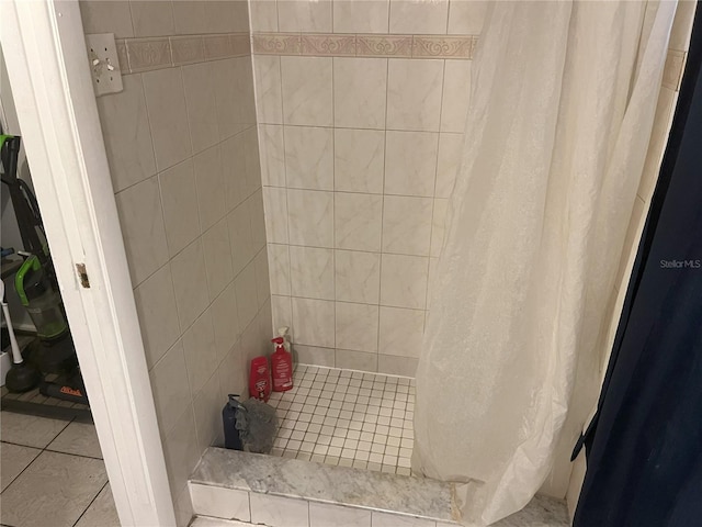 bathroom with curtained shower and tile patterned floors