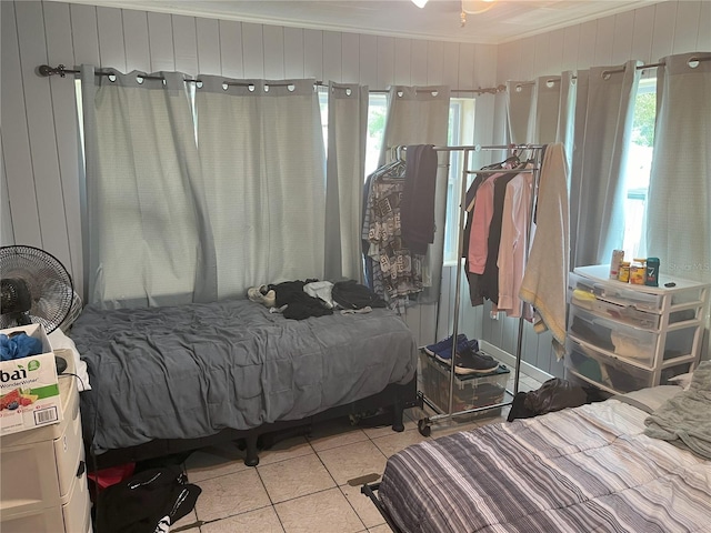 bedroom featuring multiple windows, light tile patterned floors, and crown molding