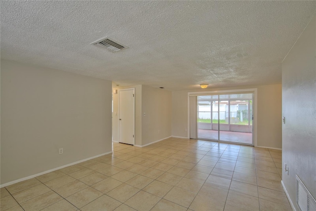 tiled spare room featuring a textured ceiling