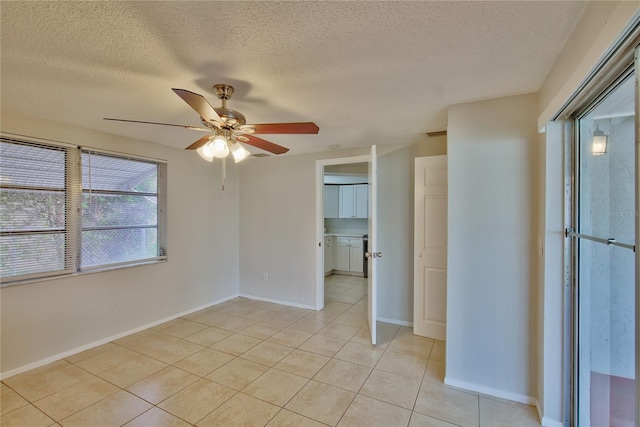 unfurnished room with a textured ceiling, light tile patterned flooring, and ceiling fan