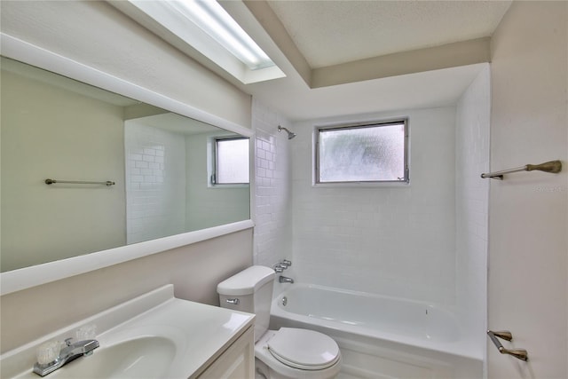 full bathroom featuring vanity, tiled shower / bath combo, toilet, and a textured ceiling