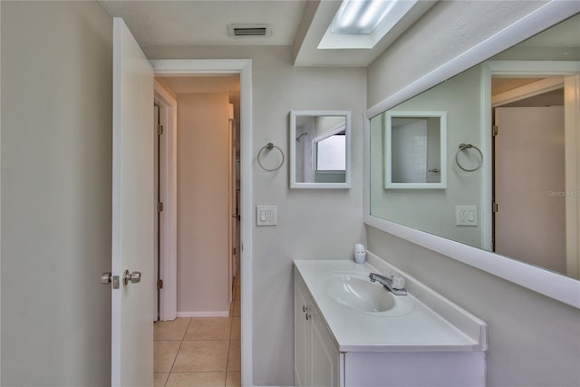 bathroom with a textured ceiling, tile patterned flooring, and vanity