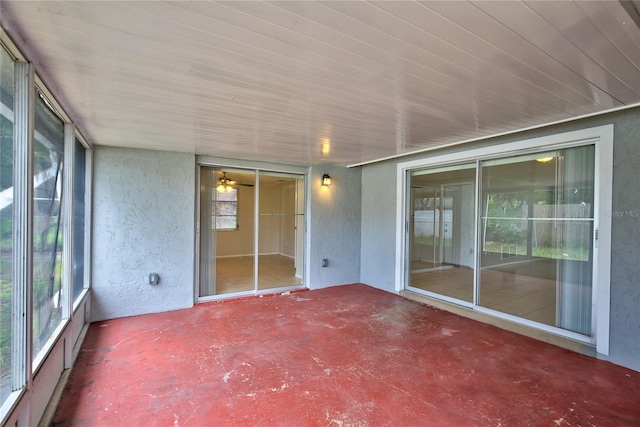 unfurnished sunroom featuring a healthy amount of sunlight and ceiling fan