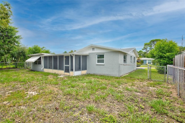 rear view of property with a sunroom and a lawn