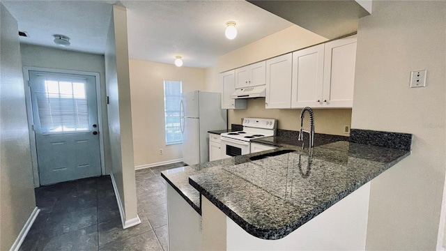 kitchen featuring under cabinet range hood, a sink, white cabinetry, white appliances, and a peninsula