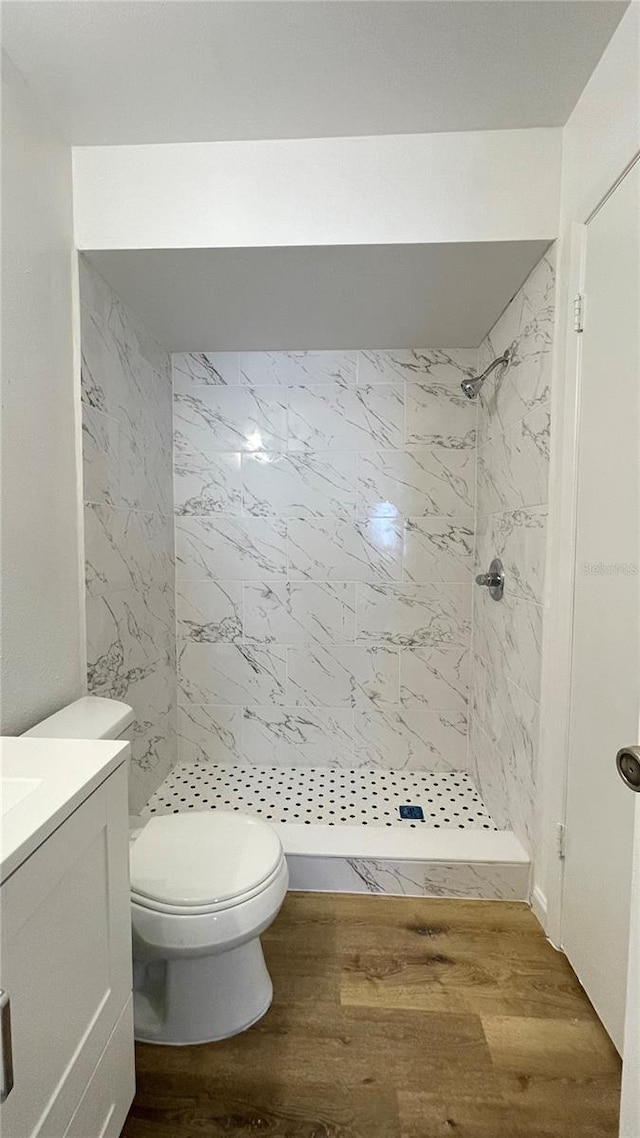 full bathroom with a shower stall, toilet, vanity, and wood finished floors